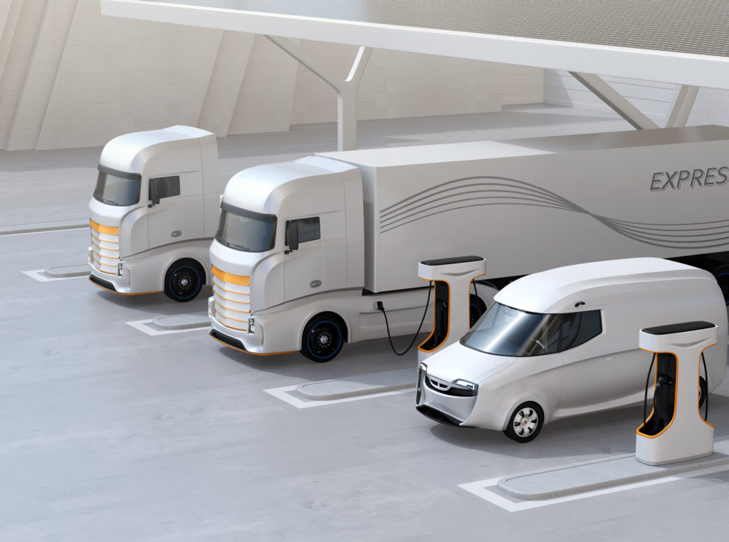 Three stylized 3d electric transport vehicles parked in depot